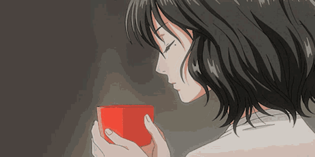 a woman is holding a red cup in her hand