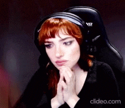 a woman with red hair wearing headphones is sitting in a chair .