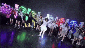 a group of girls are dancing in front of signs that say ' i love you ' on them