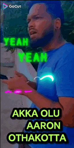 a man in a blue shirt is holding a cell phone in his hand and singing .