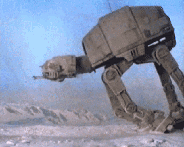 a robot is walking in the snow with a blue sky behind it