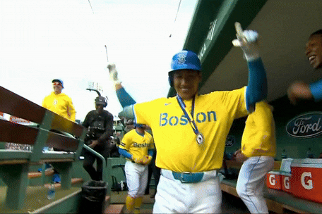 a baseball player wearing a yellow jersey with the word boston on the front