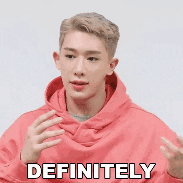 a man in a pink hoodie says definitely with his hands out
