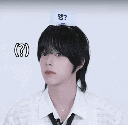 a man wearing a white shirt and tie has a white sign on his head that says ?