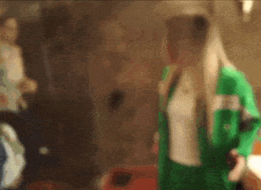 a blurry image of a woman in a green jacket