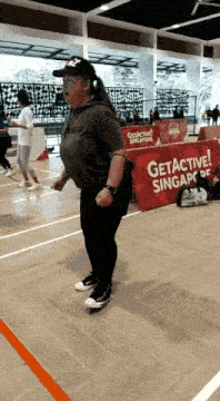 a woman stands in front of a sign that says get active singapore