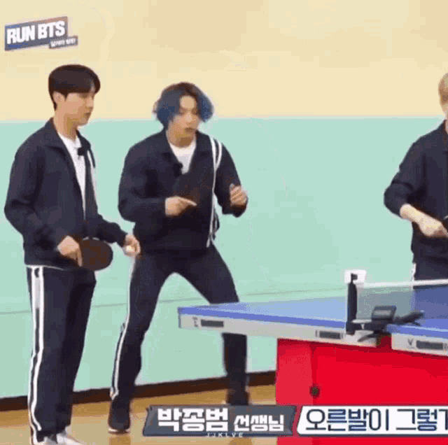 a group of young men are playing ping pong together .