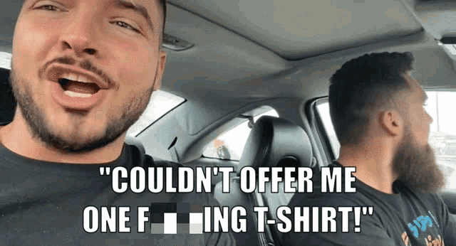 a man in a car with the words " couldn 't offer me one f ing t-shirt "