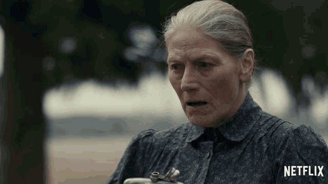 an older woman is holding a flask and a netflix logo can be seen behind her