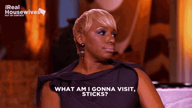 a woman sitting on a couch with the words " what am i gonna visit sticks " on her shirt