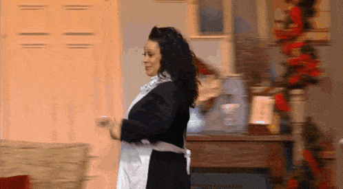 a woman in an apron is dancing in a room