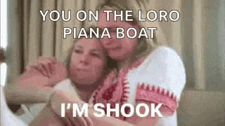 two women are hugging each other on a bed and one of them is talking .