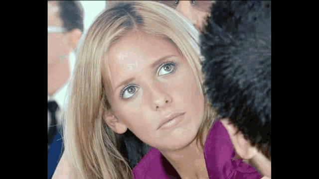 a close up of a woman 's face with a man 's face behind her .