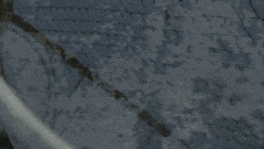 a close up of a person 's hand reaching out towards a chain link fence .