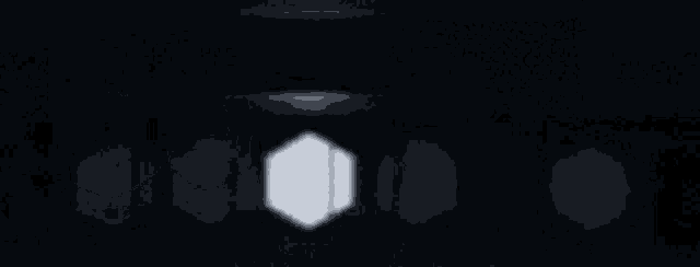 a dark room with a row of white hexagons in the middle .