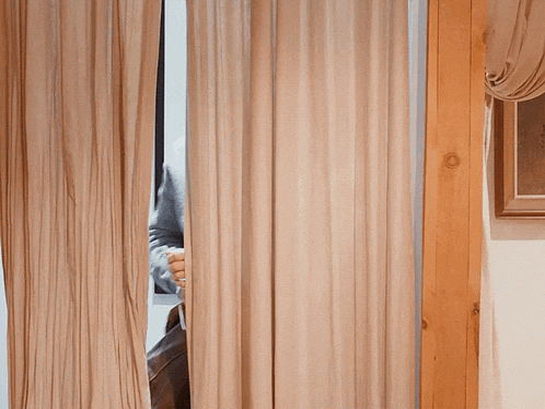 a man peeking through a curtain with the words i 'm gay