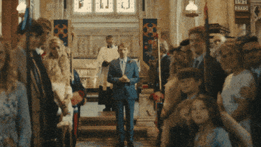 a man in a suit walks down the aisle of a church with a sign that says 905