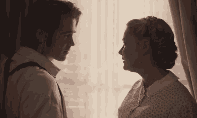 a man and a woman are looking at each other