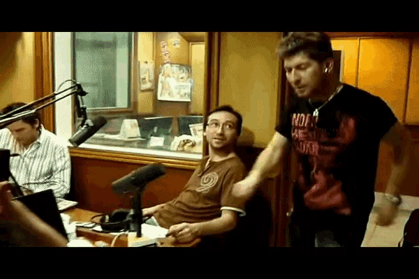 a man wearing a shirt that says ' no ' on it stands next to another man
