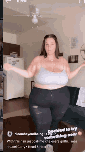 a woman with big breasts is dancing in a room