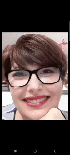 a close up of a woman wearing glasses and smiling