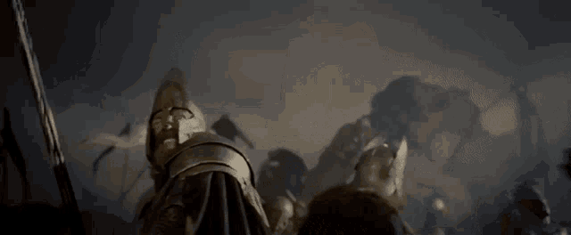 a man in a knight 's armor is standing in front of a crowd of soldiers