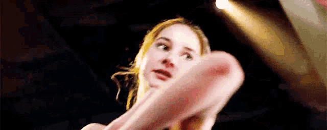 a close up of a woman holding a pink object in her hands .