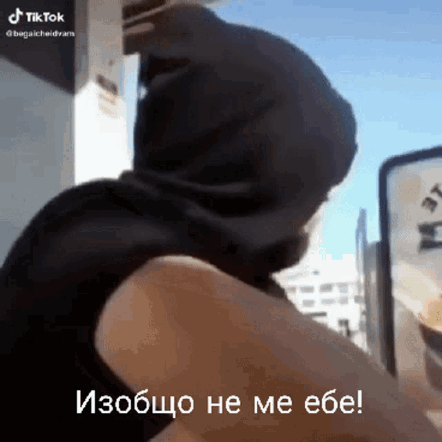a man wearing a hooded jacket is talking to someone in a foreign language