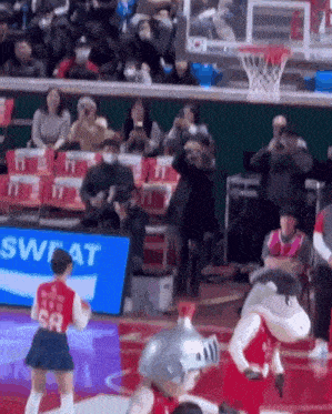 a basketball game is being played in front of a crowd .