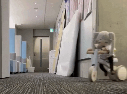 a doll is riding a tricycle down a hallway in a building .