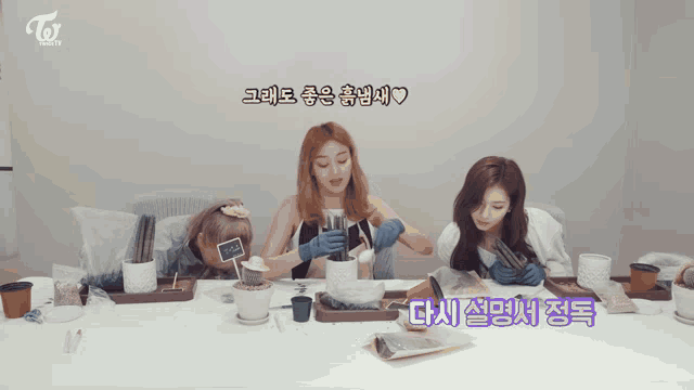 three women are sitting at a table with potted plants and a sign that says ' cactus ' on it