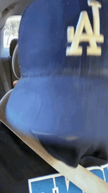 a person wearing a blue la dodgers hat is sitting in a car