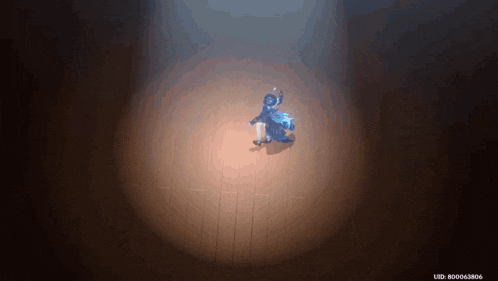 a person is dancing in a dark room with a spotlight shining on them .
