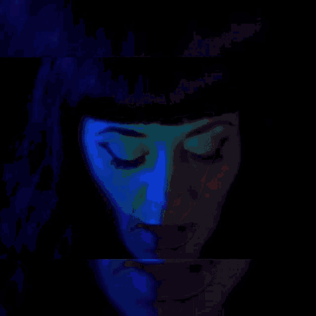 a close up of a woman 's face with red and blue lights