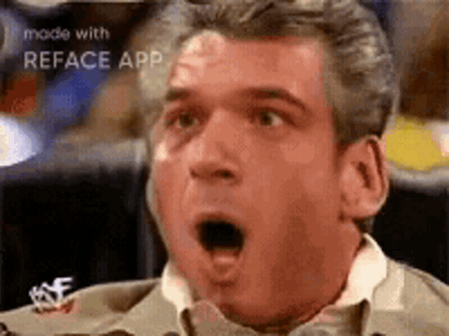 a man with a surprised look on his face is sitting in a chair .