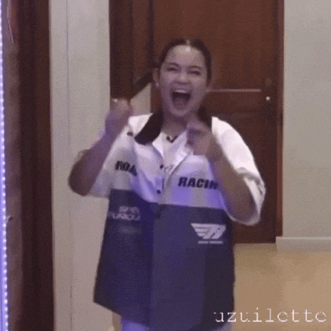 a woman wearing a jacket that says racing on it is standing in front of a door