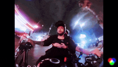 a man wearing a helmet rides a motorcycle at night