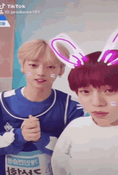 two boys are posing for a picture and one has bunny ears on their head