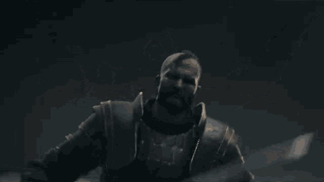 a man in armor with his arms outstretched in the air