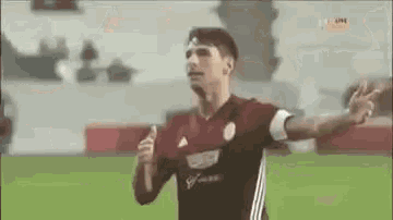 a man in a soccer uniform is running on a field .