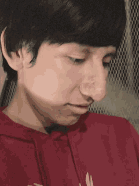 a close up of a person wearing a red shirt