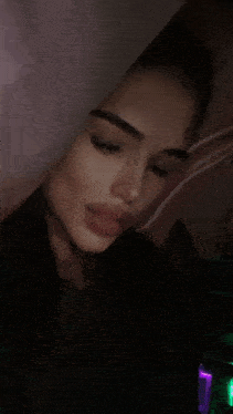 a woman 's face is partially obscured by a pink curtain