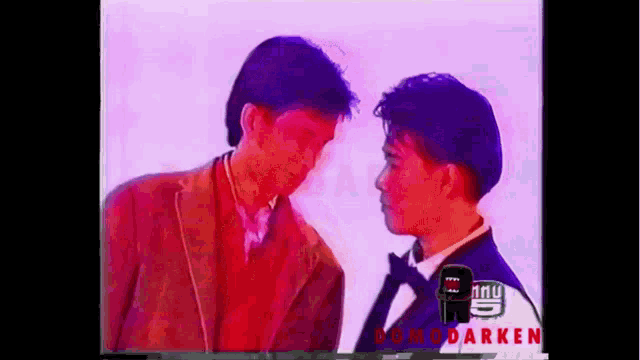 two men are standing next to each other and looking at each other with a purple background .