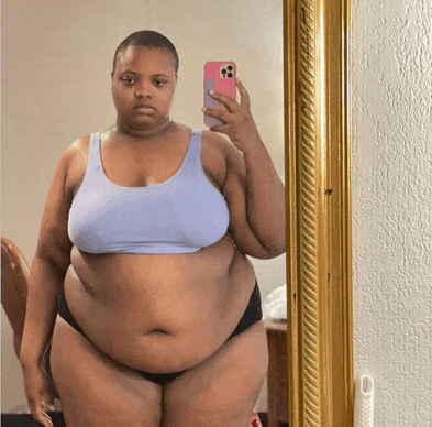 a woman takes a selfie in front of a mirror