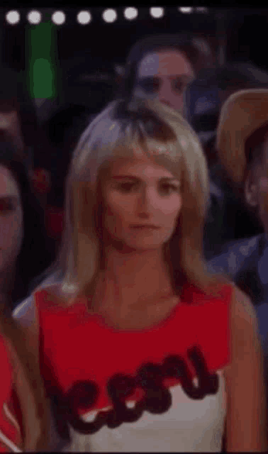a cheerleader is wearing a red and white top with the word lesu on it