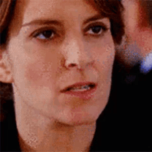 a close up of a woman 's face with a blurred background and a man in the background .