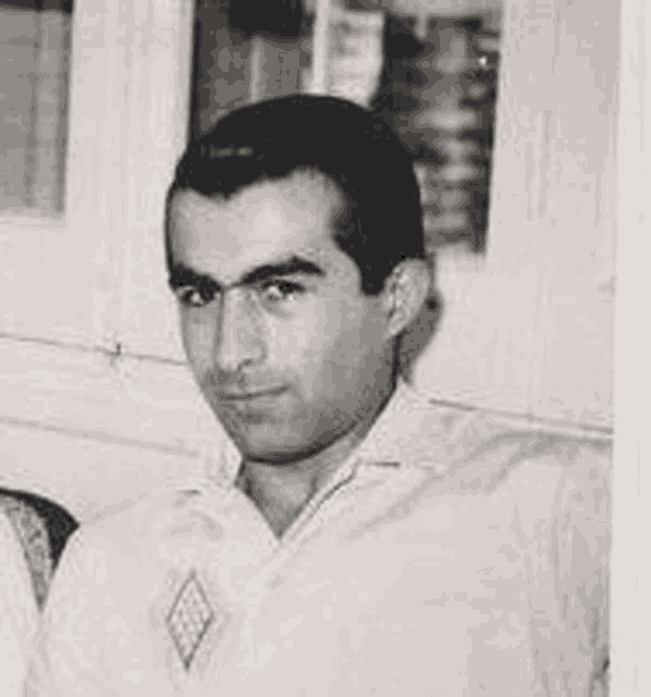 a black and white photo of a young man in a white shirt .
