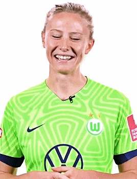 a woman wearing a green shirt with a vw logo on it is smiling with her eyes closed .
