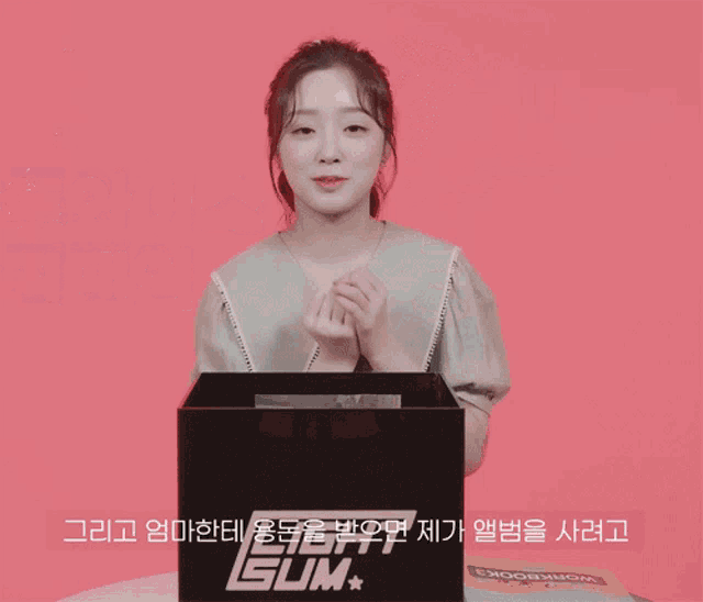 a woman is smiling in front of a pink background with chinese writing