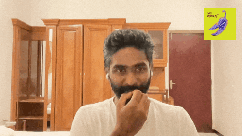 a man with a beard looks at the camera in front of a sign that says ' let 's adds ' on it